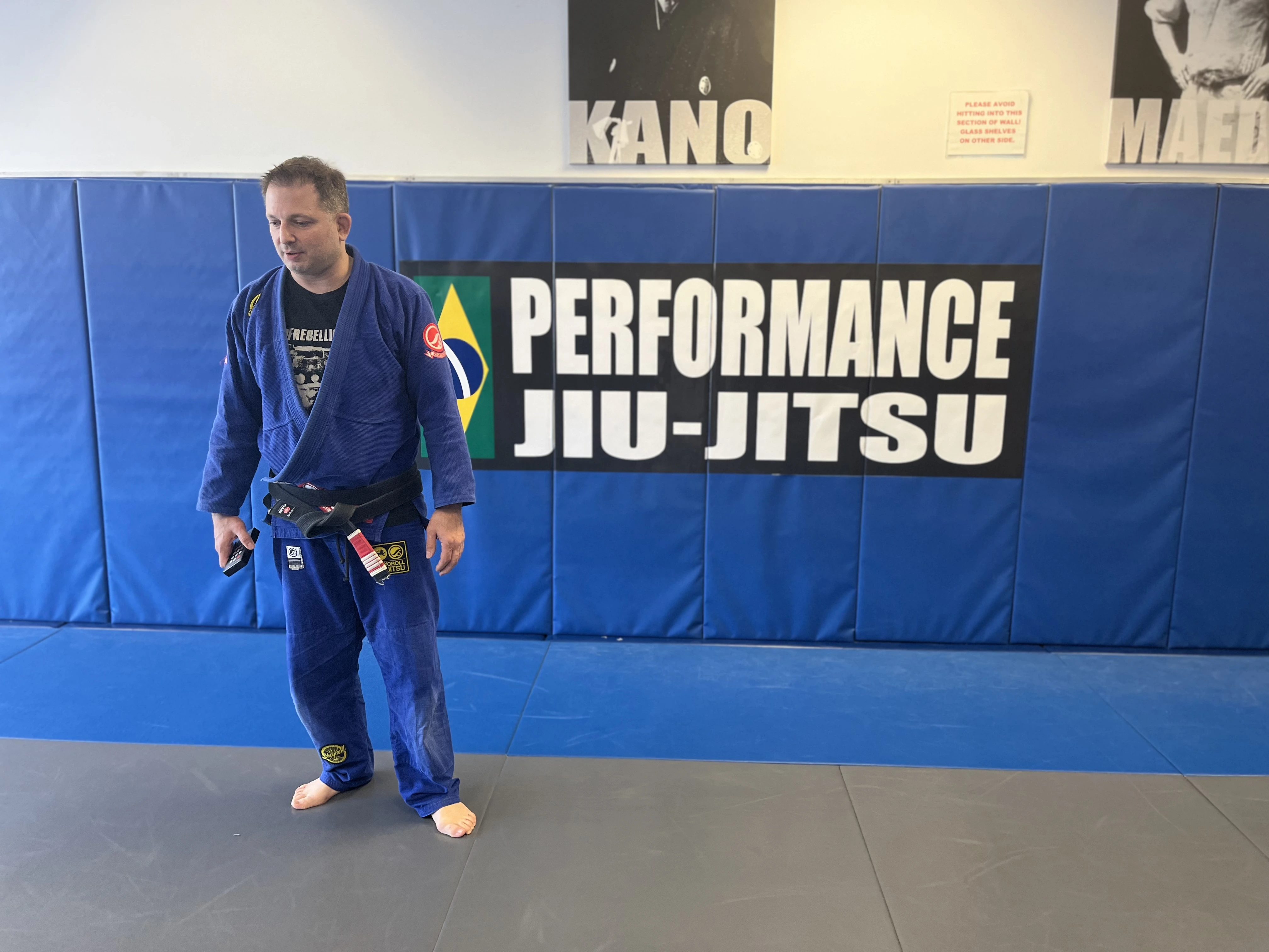 Head instructor training on the mats under the Performance Jiu-Jitsu banner in Fair Lawn, NJ